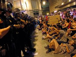 Simpatizantes del 15-M se manifiestan frente a un grupo de policías. Unos mil 'indignados' protestaron en el centro de Madrid. REUTERS  /