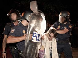 Miembros de la policia nacional, retienen a una joven durante los incidentes de los indignados frente en Madrid. EFE  /