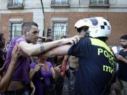Un ''indignado'' forcejea con un policía municipal en los aledaños de la Puerta del Sol. EFE  /