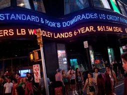 En una pantalla en Times Square de Nueva York se anuncia la baja de Standard and Poor's en la calificación a la deuda de EU. AFP  /