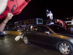 El presidente de Venezuela, Hugo Chávez, se despide mientras se dirige al aeropuerto por una avenida de Caracas . EFE  /