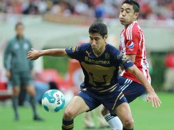 Luis Fuentes, de Pumas, cubre un esférico ante la llegada del volante rojiblanco Marco Fabián. E. PACHECO  /