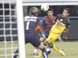 El español David Villa (centro), del Barcelona,  supera al zaguero americanista Óscar Rojas. REUTERS  /