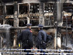 Policías observan los edificios quemados luego de los graves disturbios ocurridos esta madrugada. EFE  /