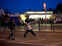 Jóvenes arrojan ladrillos a la policía en Enfield, en el norte de Londres. AP  /