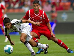 El atlista Jahir Barraza protege la pelota ante del defensor de Toluca. MEXSPORT  /