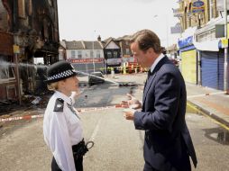 El primer ministro David Cameron se entrevista con una policía en Croydon, uno de los barrios conflictivos. REUTERS  /
