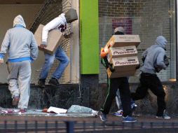 Jóvenes roban electrodomésticos de una tienda en Birmingham, Centro de Inglaterra. AP  /