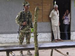Miembro del Ejército colombiano resguarda la entrada de una vivienda. EFE  /