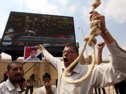 Un hombre sostiene una soga para la horca mientras observa, por pantalla gigante, la tercera sesión del juicio a Habib al Adli. EFE  /
