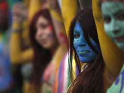 Chicas pintan su cuerpo para manifestarse enfrente del Palacio del Gobierno. AP  /