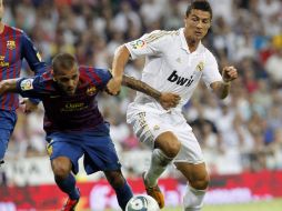 El defensa brasileño del FC Barcelona, Dani Alves (I), lucha por la pelota con el delantero Cristiano Ronaldo (D). EFE  /