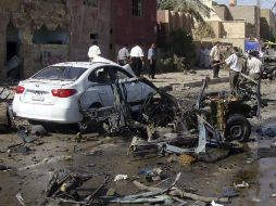 Varias personas los daños causados tras la explosión de una bomba en la ciudad de Nayaf, en Irak. EFE  /