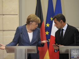 El presidente francés, Nicolas Sarkozy (d), y la canciller alemana, Angela Merkel (i), ofrecen una rueda de prensa. EFE  /