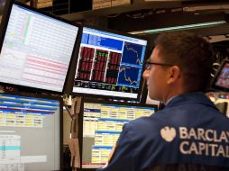 Comerciante revisa desalentado las bolsas en Nueva York, un nuevo cierre en números rojos. AFP  /