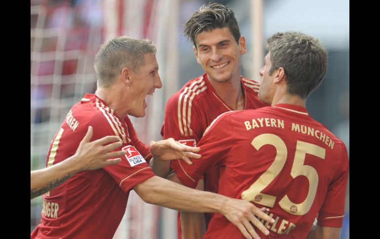 Los jugadores del Munich (I-D), Bastian Schweinsteiger, el goleador Mario Gomez y Thomas Mueller celebran el triunfo de su equipo. EFE  /