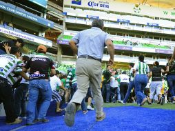 Tras escuchar las detonaciones, los aficionados saltaron a la cancha y corrieron hacia los vestidores para encontrar un refugio. EFE  /