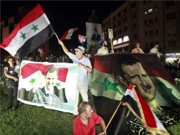 Pese a las acusaciones contra Bashar al Assad, manifestantes se pronuncian en apoyo al líder sirio. EFE  /