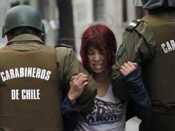 Una joven es detenida por la policía durante los disturbios. EFE  /