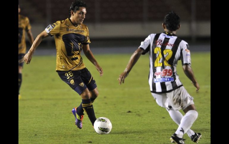 El jugador de Pumas Salvador Medina (i) es marcado por Carlos Rodríguez, de Tauro. EFE  /