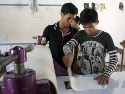 Dos alumnos del taller de grabado de la Universidad Real de Bellas Artes de Camboya preparan una plancha. EFE  /