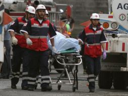 Bomberos trasladan un cadáver ayer tras el atentado. EFE  /
