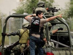 Un policía federal y soldados durante un patrullaje hoy en Monterrey, cerca del casino atacado. AP  /