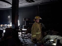 Un bombero revisa hoy entre los escombros del casino. Autoridades hallaron armas en el lugar. AFP  /