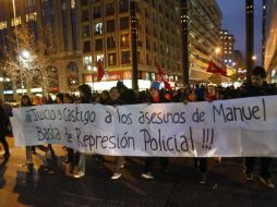 Vasias personas sostienen una pancarta en la que exigen justicia del manifestante muerto. REUTERS  /