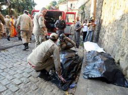 Miembros del cuerpo de bomberos de Brasil realizan el levantamiento de los cuerpos en la zona del desastre. EFE  /