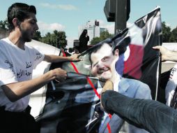 Opositores del régimen Sirio, que viven en Turquía, maltratan la imagen del presidente Bashar al Assad. REUTERS  /