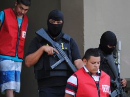 Elementos de la Agencia Estatal de Investigación escoltan a dos de los cinco detenidos por el ataque al casino Royale. NTX  /