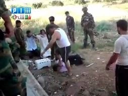 Un miembro de las fuerzas de seguridad siria golpea a un civil. Foto tomada de la televisión siria. AP  /
