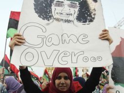 Una mujer muestra muestra una pancarta en contra de Muamar Gadhafi. EFE  /