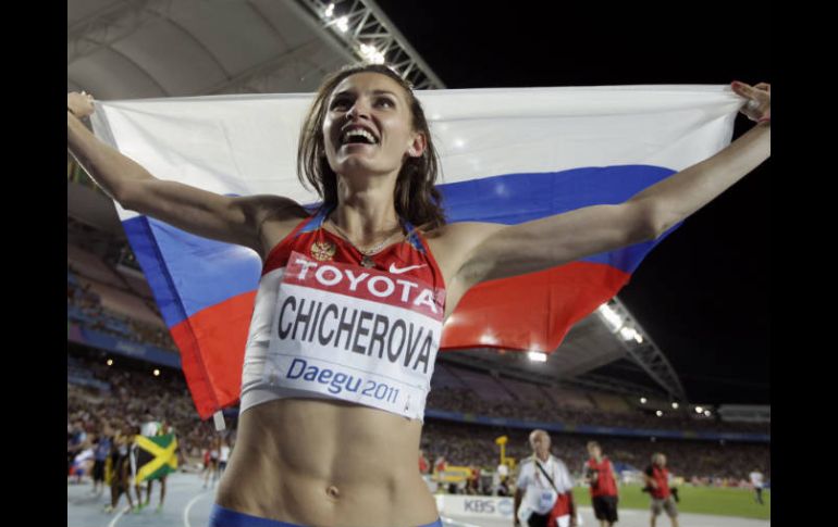 Anna Chicherova levanta su bandera al celebrar su victoria en la prueba de salto de altura. AP  /
