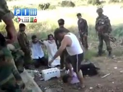 Un supuesto miembro de las Fuerzas de Seguridad sirias, vestido de civil proporciona una brutal paliza a otro hombre. EFE  /