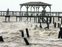 Residentes caminan sobre el muelle del Lago Pontchartrain, en Slidell, Louisiana, al este de Nueva Orleans. AP  /