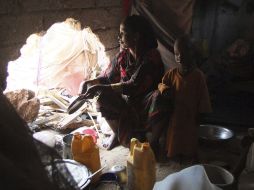 Una mujer prepara comida para sus hijos en un edifcio destruido de Mogadiscio. AP  /