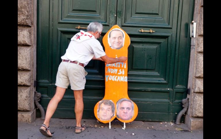 Un hombre pone un cartel con la leyenda Los derechos no se tocan en la puerta del ministerio de administración pública. EFE  /