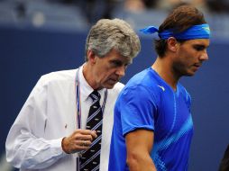 El tenista español Rafael Nadal conversa con el árbitro Brian Earley (I) con el juego detenido por la lluvia durante su partido. EFE  /