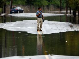 Un residente camina entre charcos hoy, en el vecindario de Manayunk en Filadelfia. AP  /