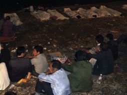 Los residentes se sientan frente a los cuerpos de las víctimas. REUTERS  /