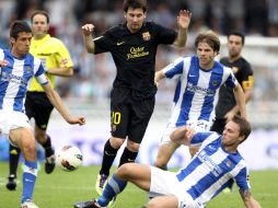 Lionel Messi intenta safarse del bloqueo de los jugadores del Real Sociedad. EFE  /