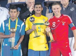 El salvadoreño Velásquez (Balón de Bronce), el brasileño André (Plata) y el ruso Leonov (Oro), muestran sus premios. AP  /