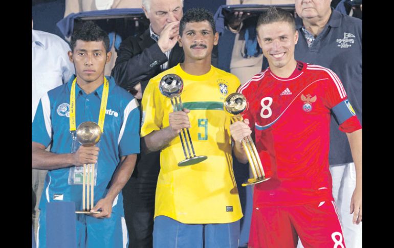 El salvadoreño Velásquez (Balón de Bronce), el brasileño André (Plata) y el ruso Leonov (Oro), muestran sus premios. AP  /