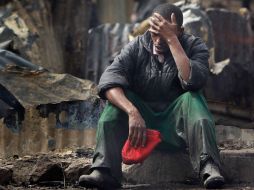 Joseph Mwangi de 34 años, absorto tras descubrir los cuerpos calcinados de dos de sus hijos hoy en Nairobi. AP  /