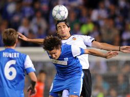 El jugador del Genk, Jelle Vossen (C) domina el balón delante de Mehmet Topal de Valencia (D). AFP  /