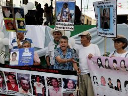 Los integrantes de la movilización llevan consigo pancartas en las que reclaman a los muertos y desaparecidos en México. AP  /