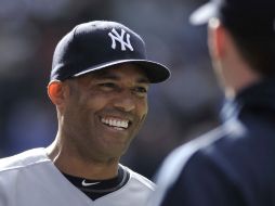 Mariano Rivera sonríe durante el juego al ser felicitado por su lanzamiento perfecto ante los Azulejos de Toronto. AFP  /