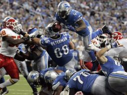 Jahvid Best (44), de los Leones, salta con el balón en la lucha de 'titanes' que se dió en Michigan. REUTERS  /